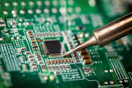 Soldadura de un procesador de micro chip con herramienta de hierro green circuit boad. Tecnología de servicio de electrones y fondo de concepto de macro computadora. photo