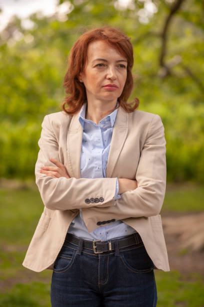 istock one mature woman, serious expression, posing in park. looking sideways. 1169554084