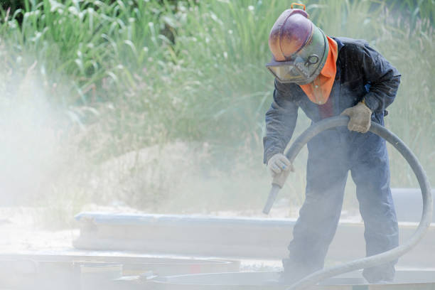 Worker is remove paint by air pressure sand blasting