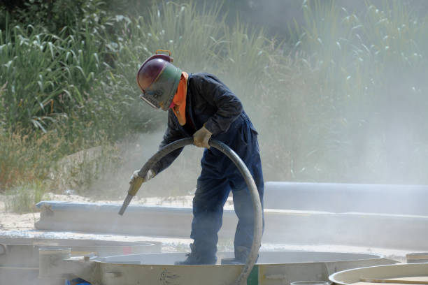 istock Worker is remove paint by air pressure sand blasting 1169554256