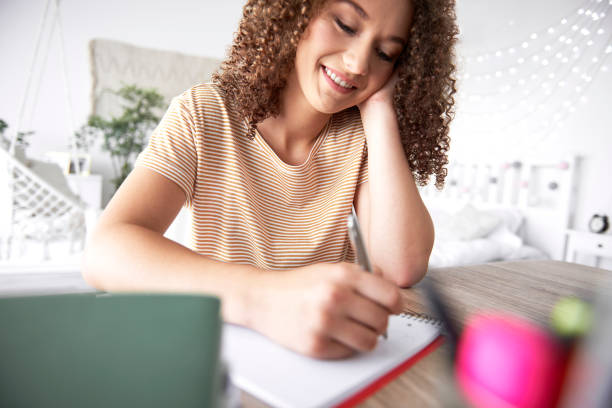 istock Young woman writing at the table 1169555827