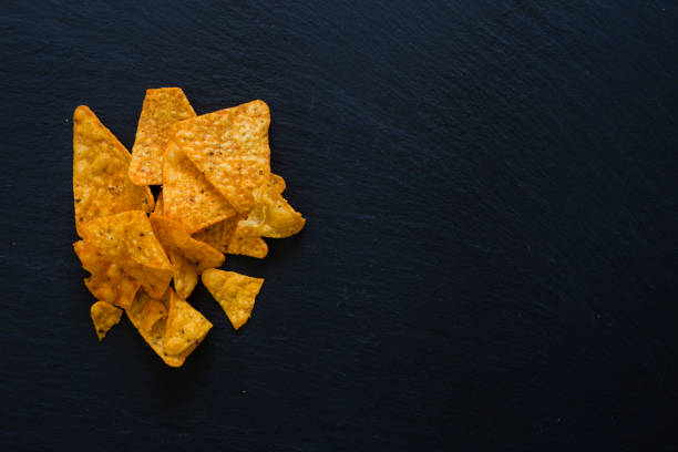istock Group of natural nacho chips on dark background 1169556011