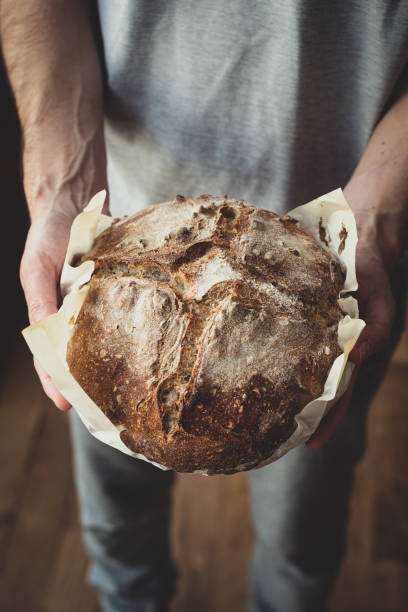 istock Baked bread of sourdough in hands 1169559117