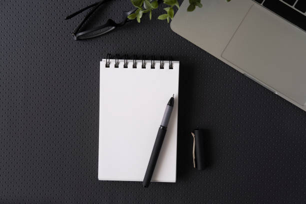 istock Top view with copy space of office leather desk table with computer supplies. 1169560797