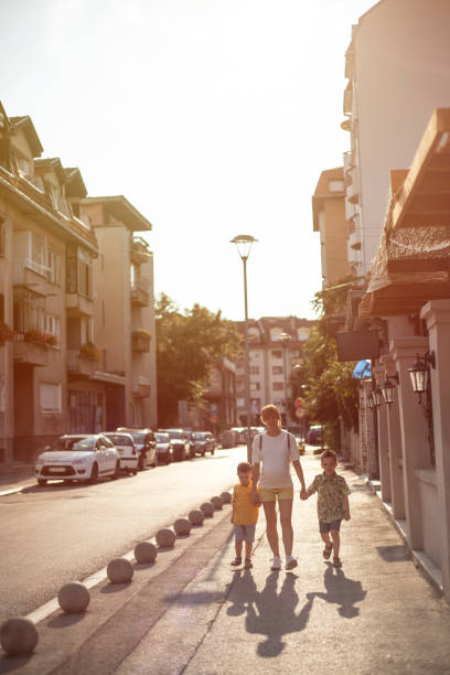 istock Pregnant woman walking with her two sons 1169560924
