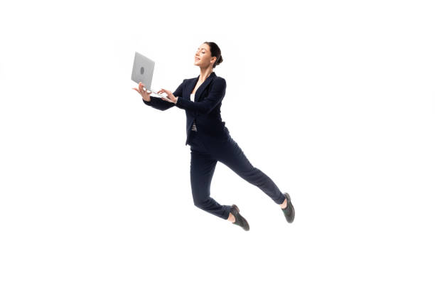 junge fröhliche geschäftsfrau mit laptop, während schweben isoliert auf weiß - levitation stock-fotos und bilder