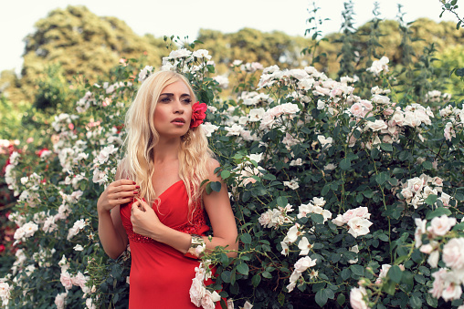Mature blonde in the garden with roses