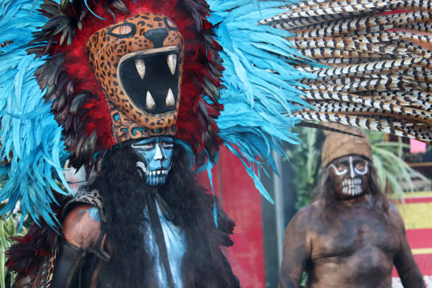 Alangasi, Quito, Pichincha, Ecuador - April 15, 2022: Young adults dressed in traditional costumes, wielding knives and carrying religious banners, participating in the Diablos de Alangasi procession during Holy Week in Quito, Ecuador