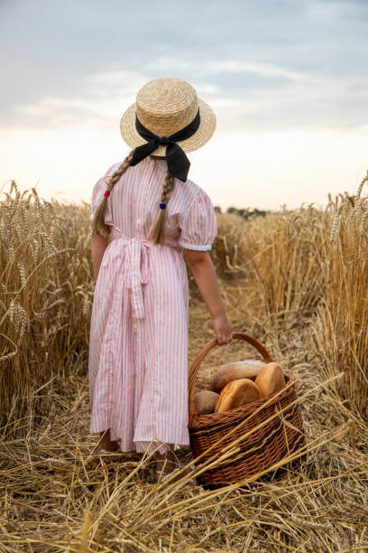 bambina in possesso di un cesto di pane. - loaf of bread bread 7 grain bread healthy eating foto e immagini stock