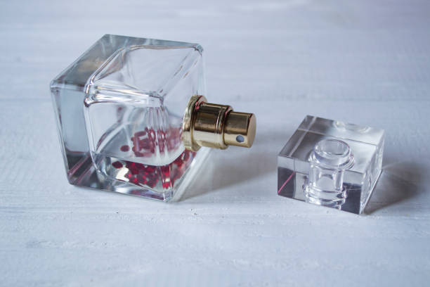 istock Perfume bottle on a white wooden table. 1169564919