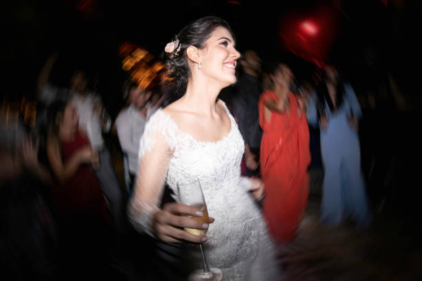 bride holding a glass of champagne and dancing - life events laughing women latin american and hispanic ethnicity imagens e fotografias de stock