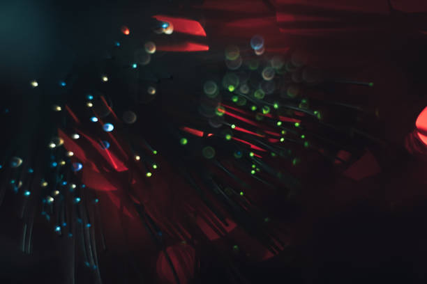 istock Beautiful multi-colored abstract optical fiber line on a red bokeh background. 1169566016