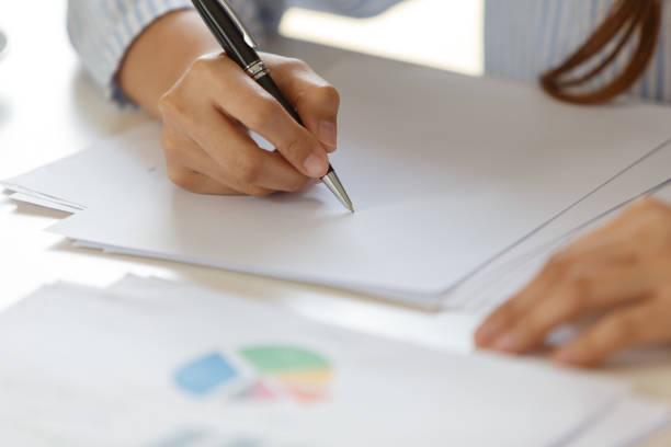 istock Woman hand with pen writing on notebook. 1169566197