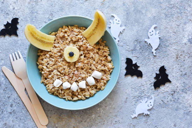 Halloween treat. A creative idea for a children's lunch is porridge, with berries and marshmallows. Funny lunch for children on Halloween. stock photo