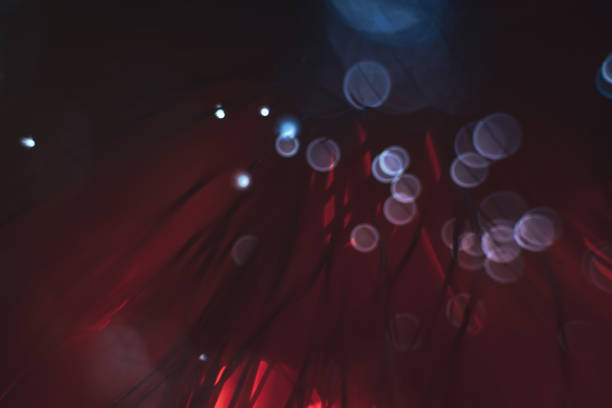 istock Beautiful abstract optical fiber line on a red bokeh background. 1169569244