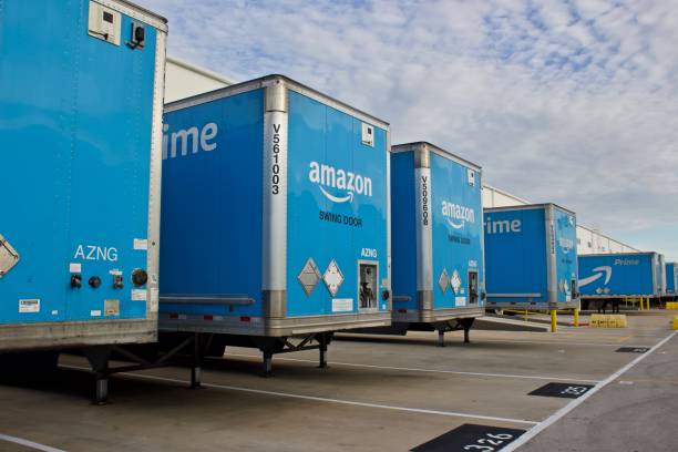 Amazon Prime Trailers at distribution center Miami, Florida August 17,2019 multiple blue Amzon prime trailers backed into bays at a distribution center to unload products for area customers. amazon.com photos stock pictures, royalty-free photos & images