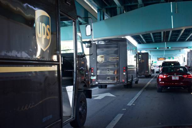 camiones de reparto ups en la intersección - teamsters fotografías e imágenes de stock