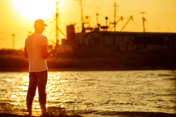 istock Young man fishing at sea 1169574251