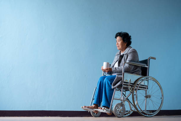 verticale d'une femme aînée dans le fauteuil roulant. - mental health women asian ethnicity bicycle photos et images de collection