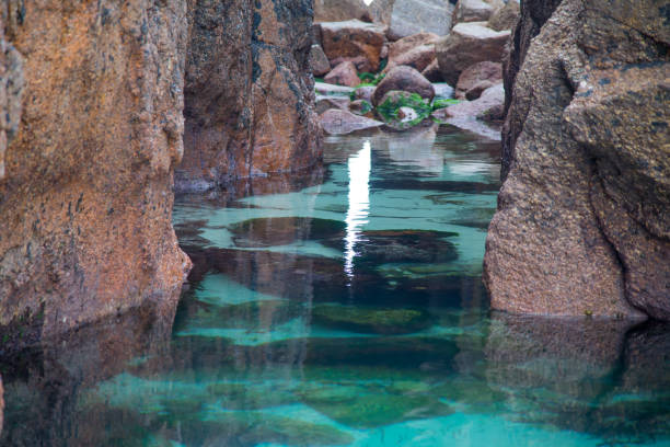 A large azure coloured pool at Nanjizel beach, Cornwall, in summer
