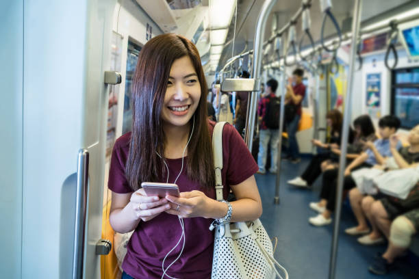istock Smiling Woman Using Phone While Traveling In Train 1169581788