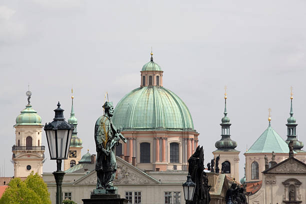 statues on the Charles Bridge (Karlův Most) with the top of Prague's Klementinum in the middle; Prague, Czech