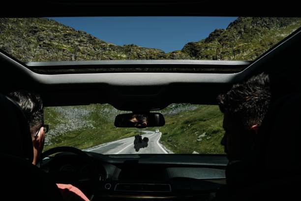 Breathtaking mountain road winding through the Susten Pass in the Swiss Alps, captured on a scenic summer road trip. Dramatic alpine peaks, lush green valleys, and clear blue skies create a stunning natural landscape. Ideal for travel, adventure, freedom, and nature concepts.