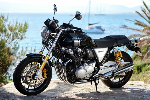 Majorca, Spain - May 29, 2019: On foreground lonely Honda CB1100 model modern naked bike, on background yachts moored on Mediterranean waters. Most convenient movement on the island on a motorcycle