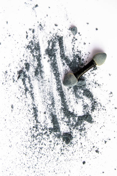 istock Scattered shiny powder blast, gray eyeshadow and makeup brush isolated on white background, vertical shot 1169593710