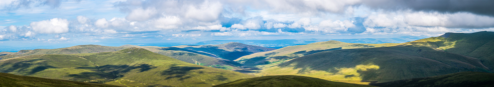 A panoramic aerial view of a beautiful valley with hills and mountains on a sunny day