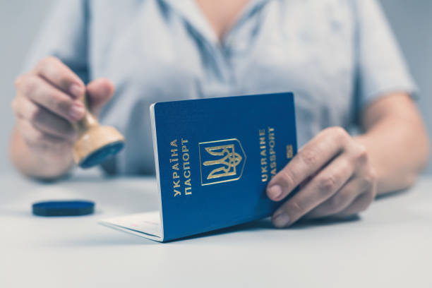 Immigration and passport control at the airport. woman border control officer puts a stamp in the Ukrainian passport. Concept stock photo