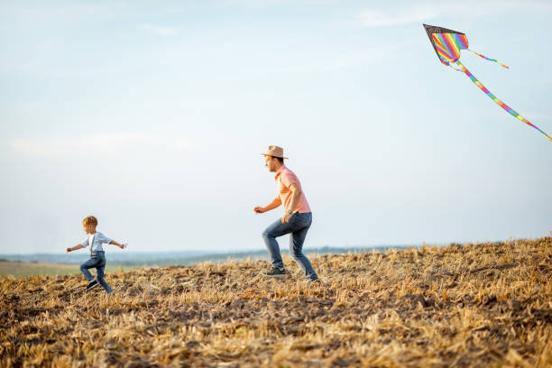 istock Fother and son flying kite on the field 1169597293