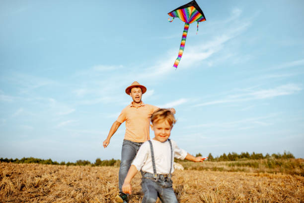 istock Fother and son flying kite on the field 1169597305