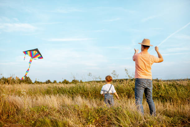 istock Father and son with air kite in the field 1169597979