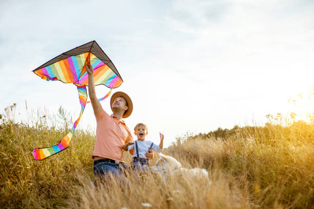 istock Father and son with kite on the field 1169597981