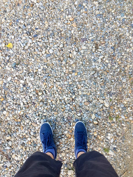 istock Top view blue sneakers on gravel 1169598038