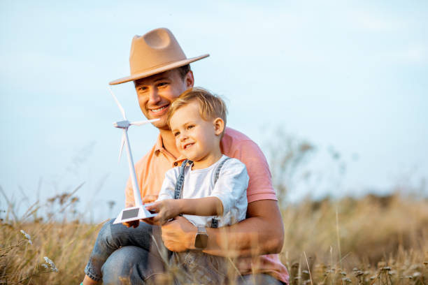istock Father and young son playing with wind turbine 1169598321