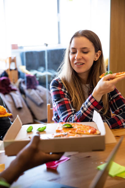 istock Lunch break in the office with a fresh made pizza 1169601366
