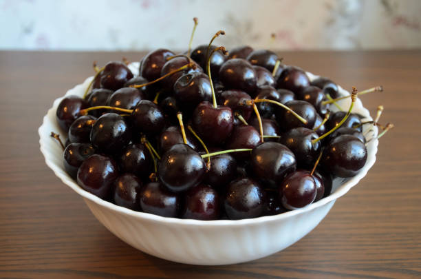 istock Wet chilled cherries with peduncles in bowl on table 1169605939