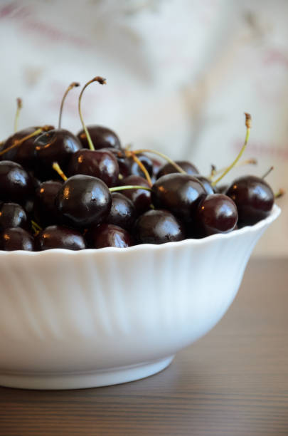 istock Wet chilled cherries with peduncles in bowl on table 1169606006