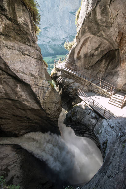 vista delle cascate che scendono a cascata lungo la gola rocciosa - waterfall footbridge switzerland rapid foto e immagini stock