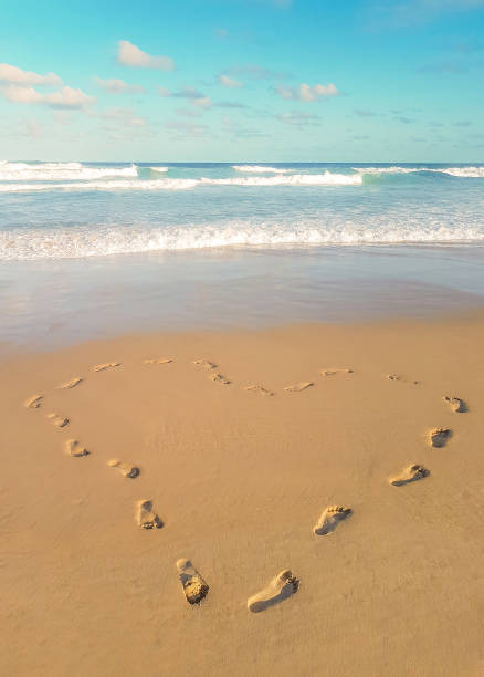 istock Footprints in the sand, heart shaped. 1169609695