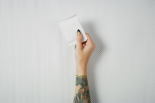 Studio shot of an unrecognizable woman holding a sanitary pad against white background