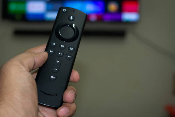 Amazon fire stick TV remote in hand Amazon fire stick TV remote in hand television show stock pictures, royalty-free photos & images