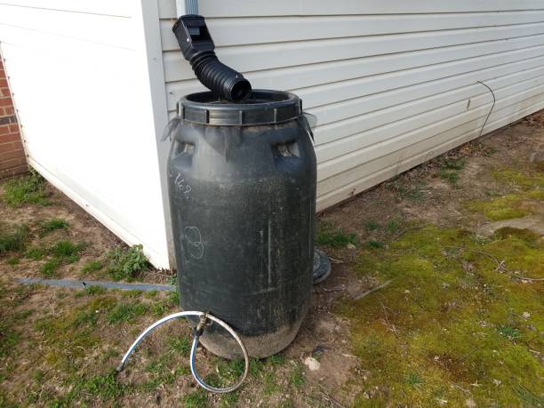 istock black rain barrel with gutter downspout and hose 1169615497