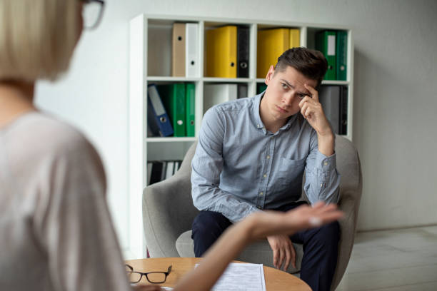 istock Depressed man listening to counsellor 1169616609