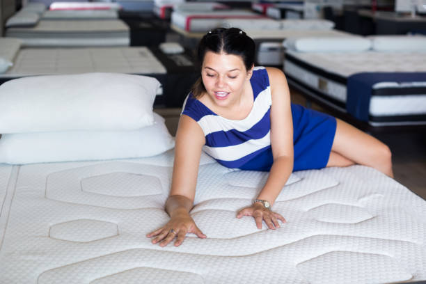 istock woman is lying on bed and testing mattress for relax 1169617736