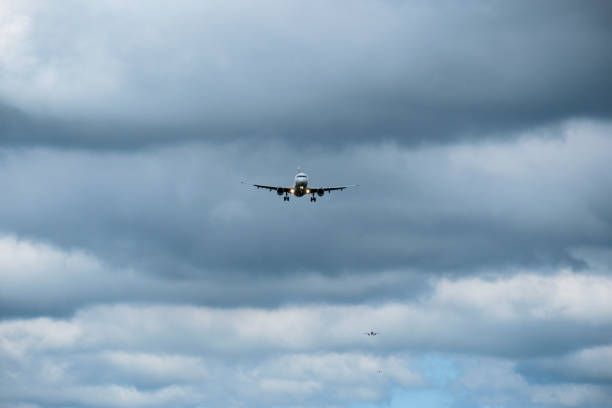 istock Airplane in landing approach with dark cloudscape 1169618250