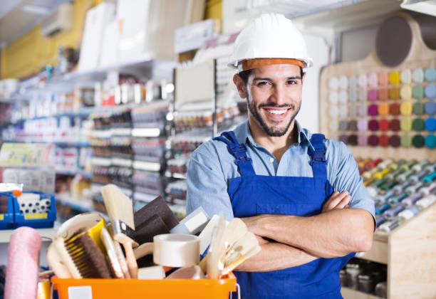 istock Smiling man painter with folded arms in paint shop 1169619205