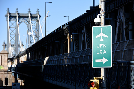 INFORMATION SIGN ON BRIDGE AGAINST SKY IN CITY
